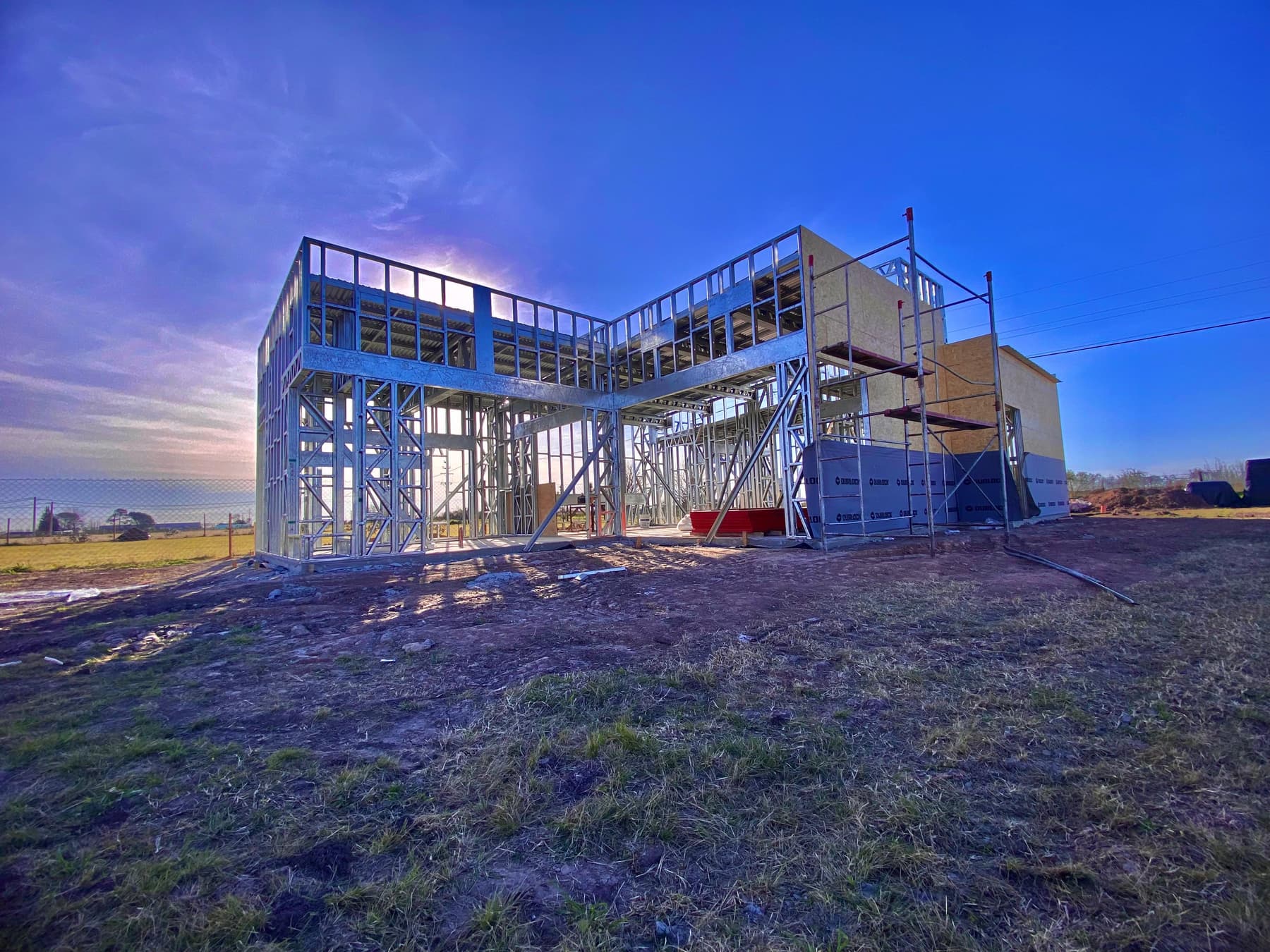 Estructura de acero galvanizado de una vivienda de dos plantas en montaje, al atardecer